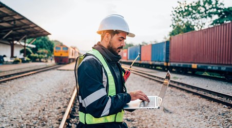 Ingenieur mit Laptop am Gleis